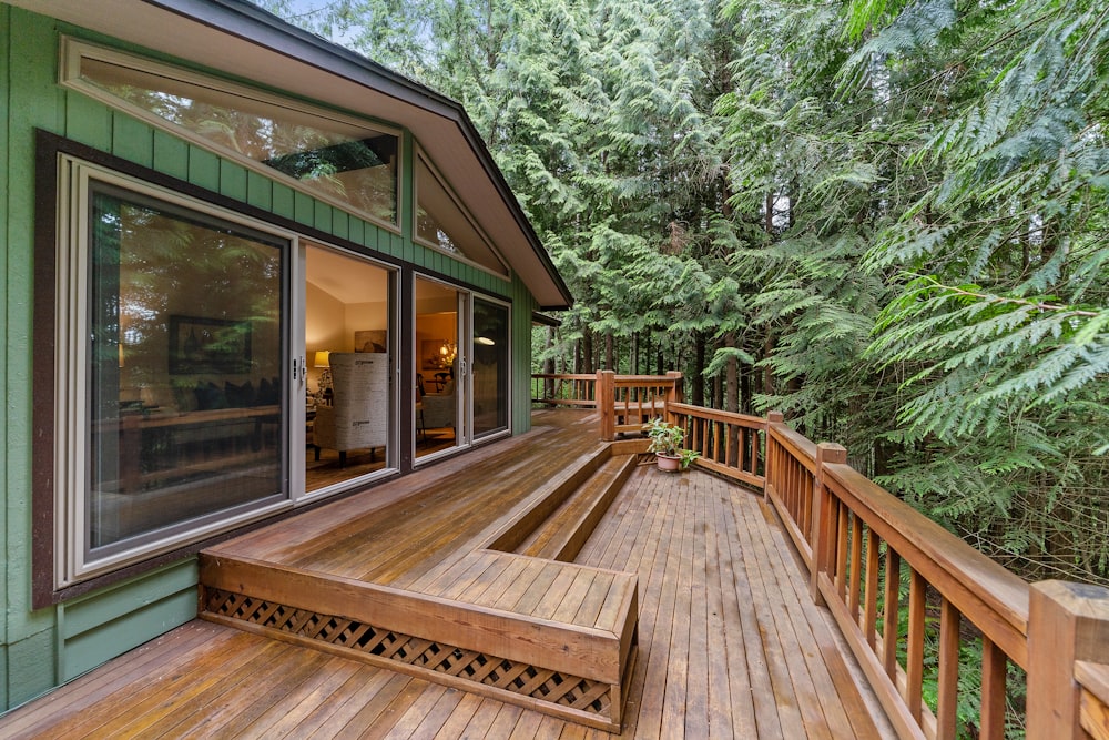 Terrasse en bois construite en extension d'une maison, entourée d'arbres